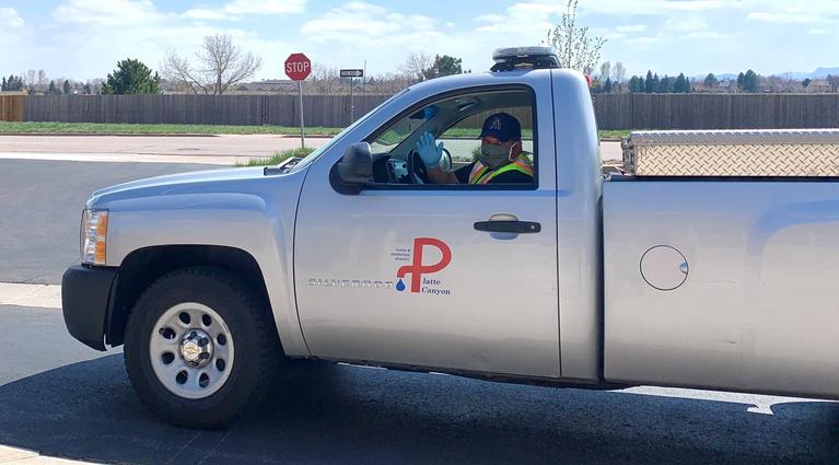 Field staff member wearing a mask in district vehicle. 